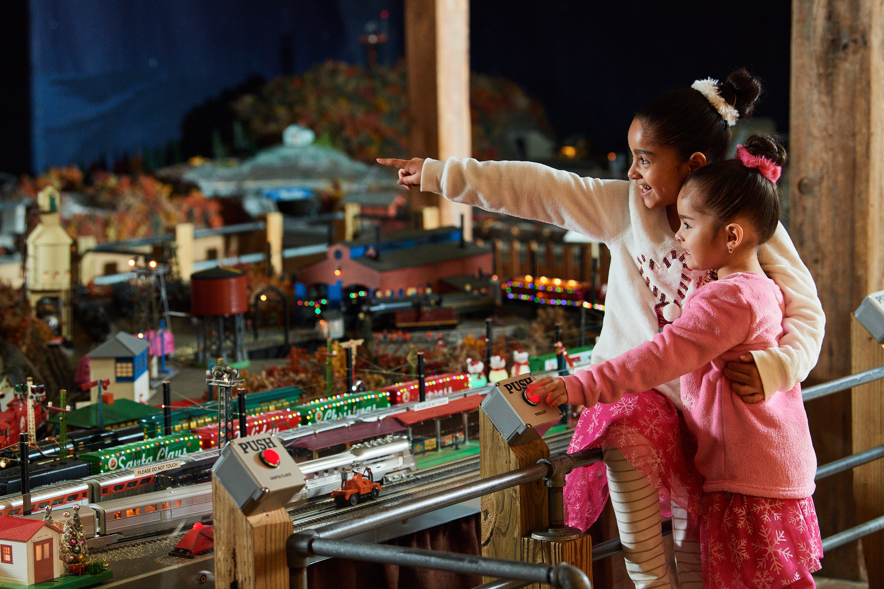 Two young girls pointing at the Brandywine Railroad model train display.