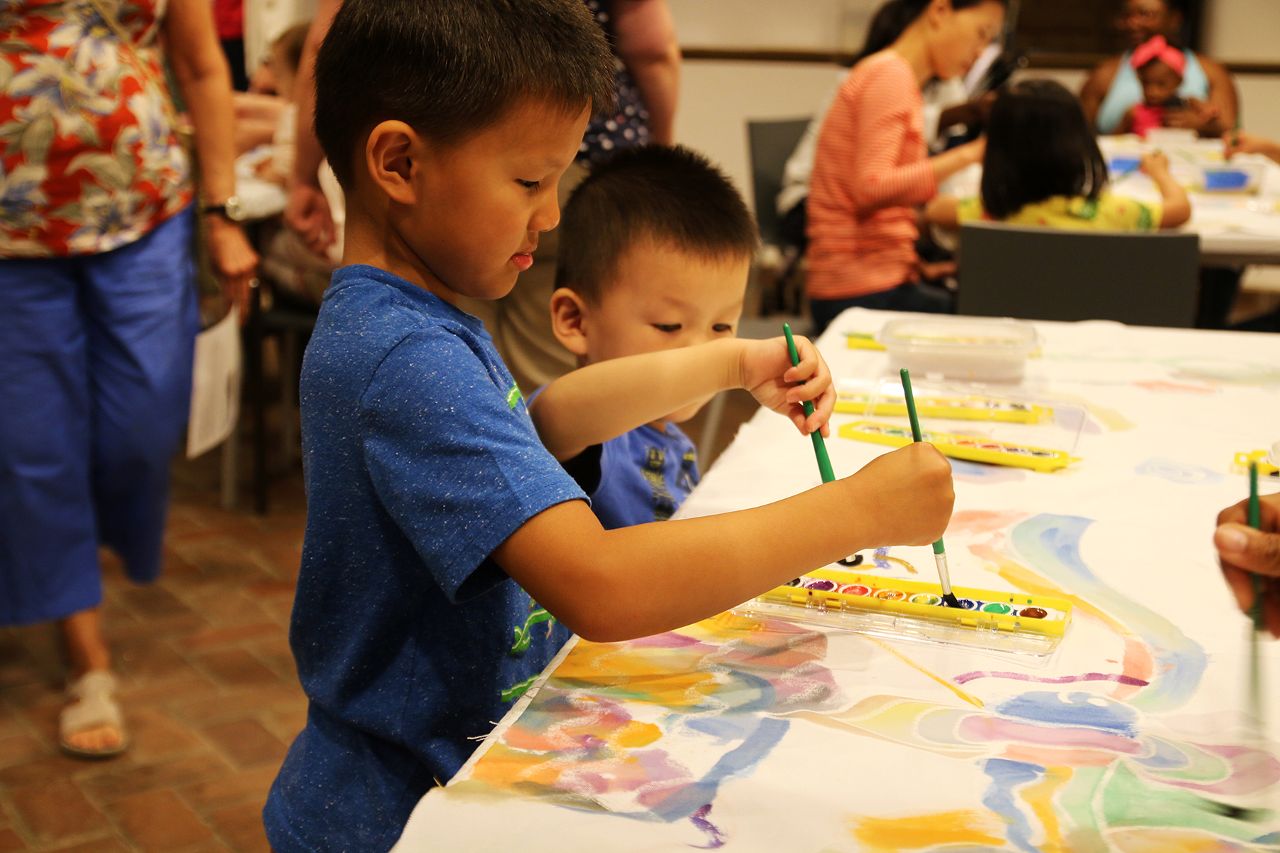 Two young children painting with watercolors