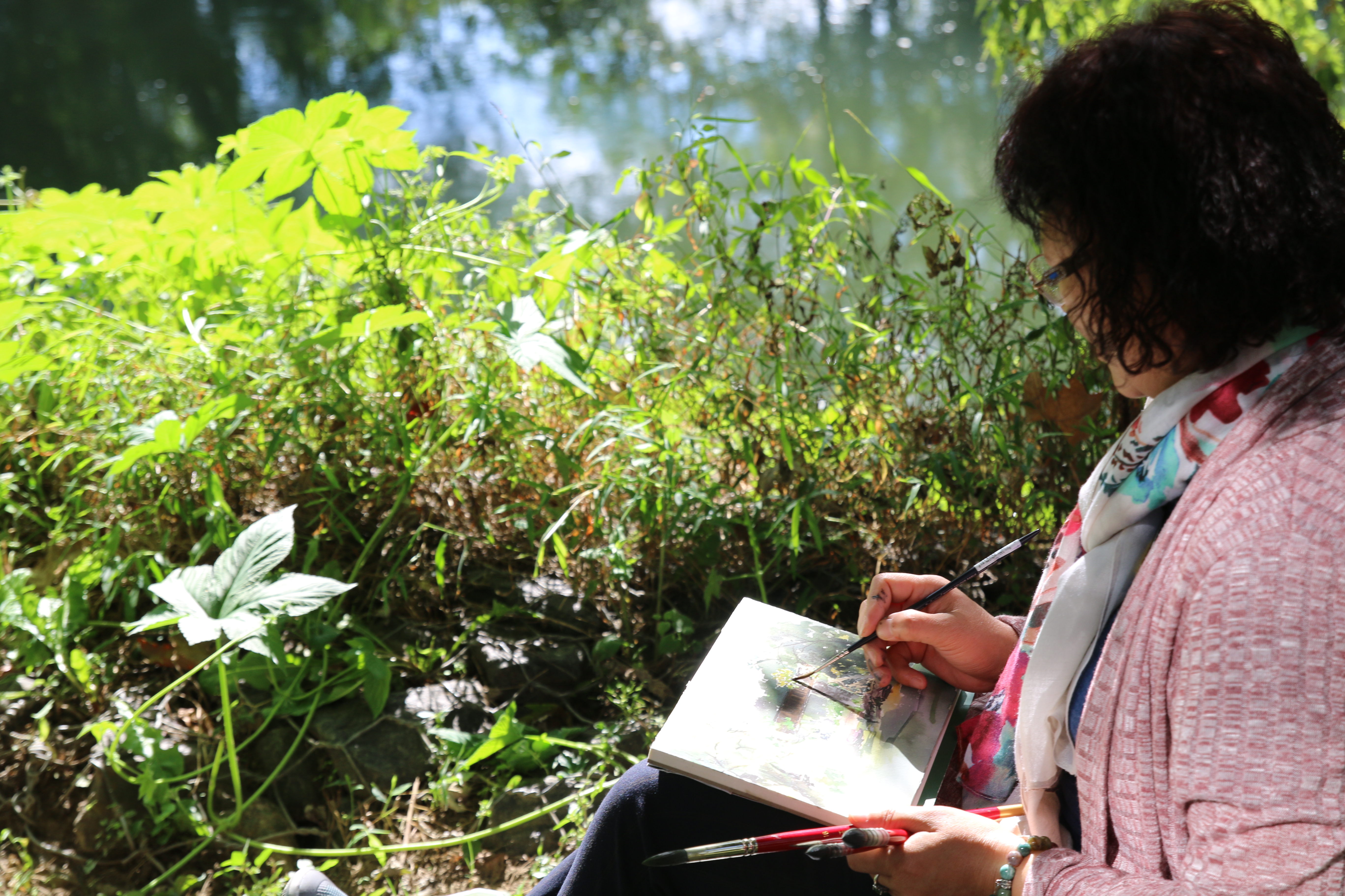 Person sitting in nature and drawing