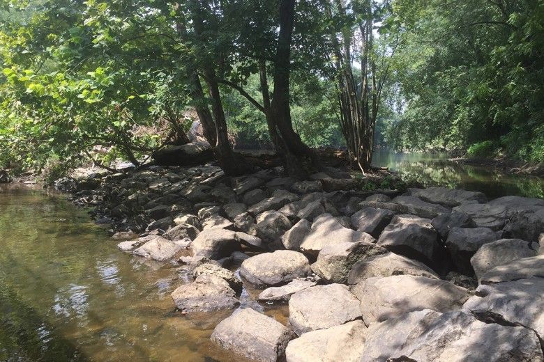 landscape photo of large rocks creating a dam across a waterway