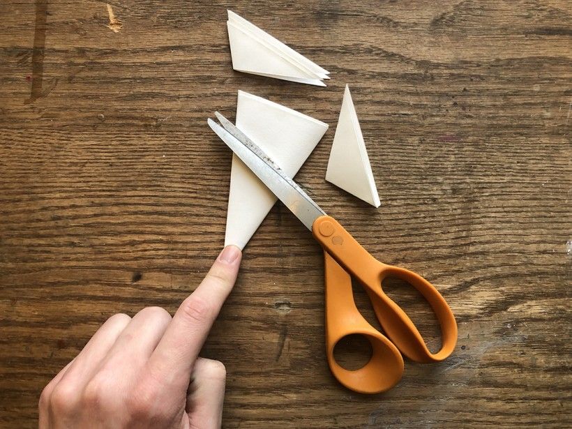 Scissors cutting up snowflake paper