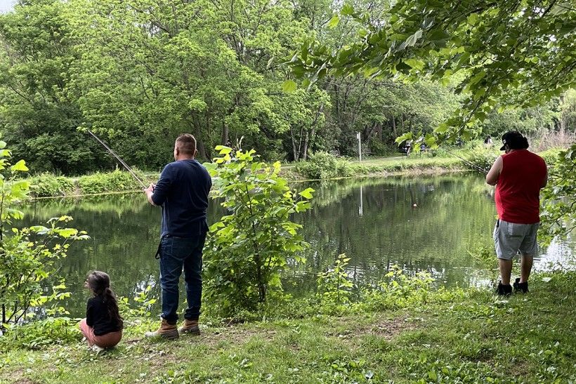 landscape photo of a family fishing along a waterway