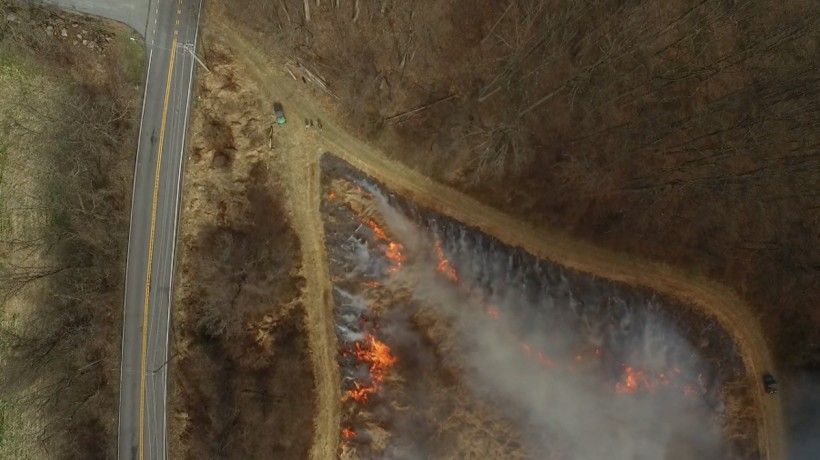 Triangular area mid-burn showing precise control of fire direction so that it can burn in two directions at once, with the flames moving toward the center. Photo by Jim Moore.