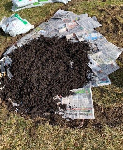 Starting a garden with soil and a base layer of newspaper.