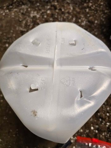 photo of the bottom of an empty milk jug with holes punched in it for drainage